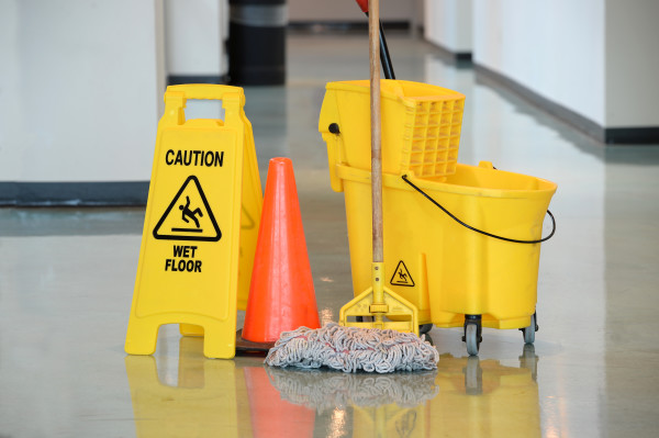 Wet Floor Sign With Mop Caution sign with mop and bucket on office floor